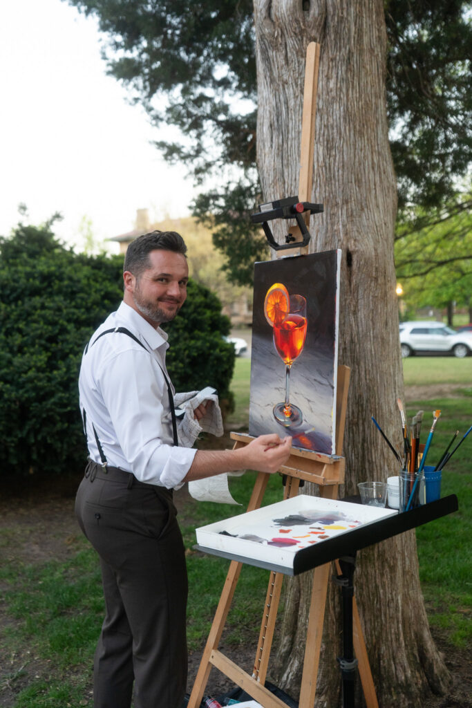 Artist creating a live painting at a special event, capturing the moment on canvas.